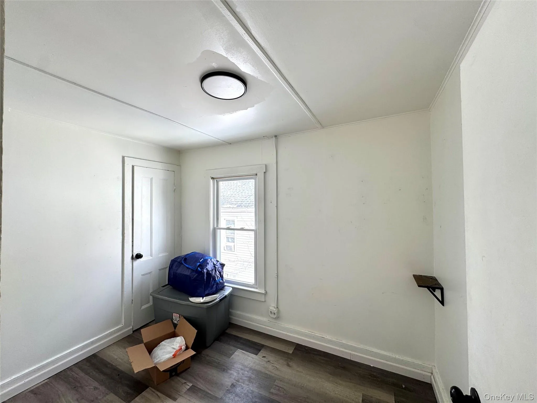 Empty room with dark wood-style floors and baseboards Empty room with dark wood-style floors and baseboards
