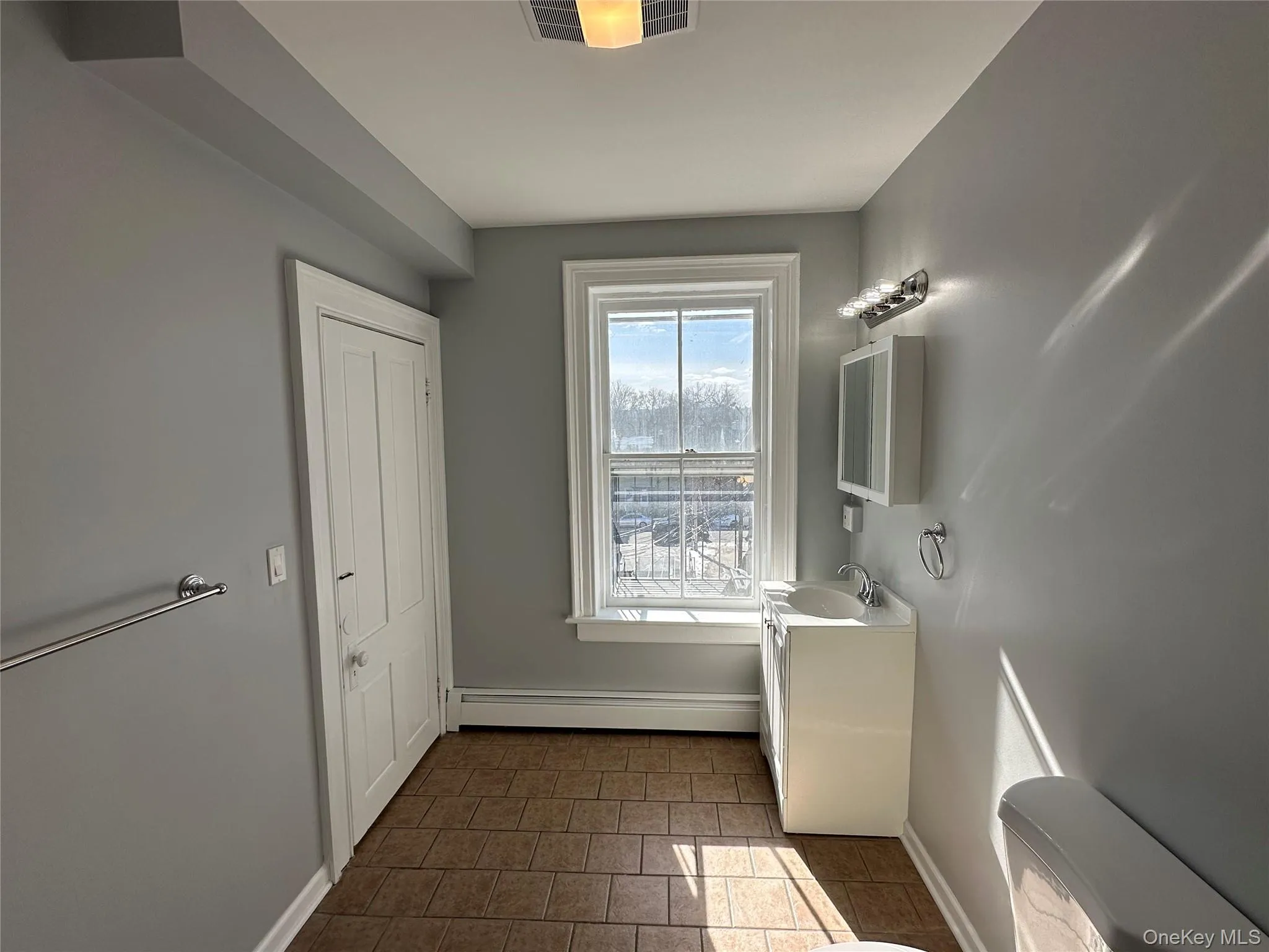 Bathroom with a baseboard radiator, toilet, and vanity Bathroom with a baseboard radiator, toilet, and vanity