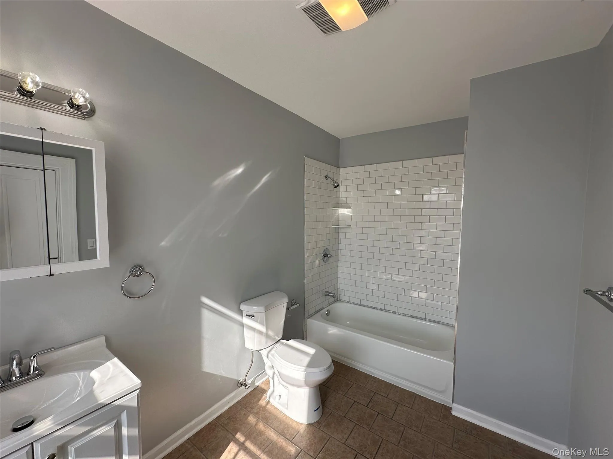 Full bathroom with tiled shower / bath combo, toilet, and vanity Full bathroom with tiled shower / bath combo, toilet, and vanity