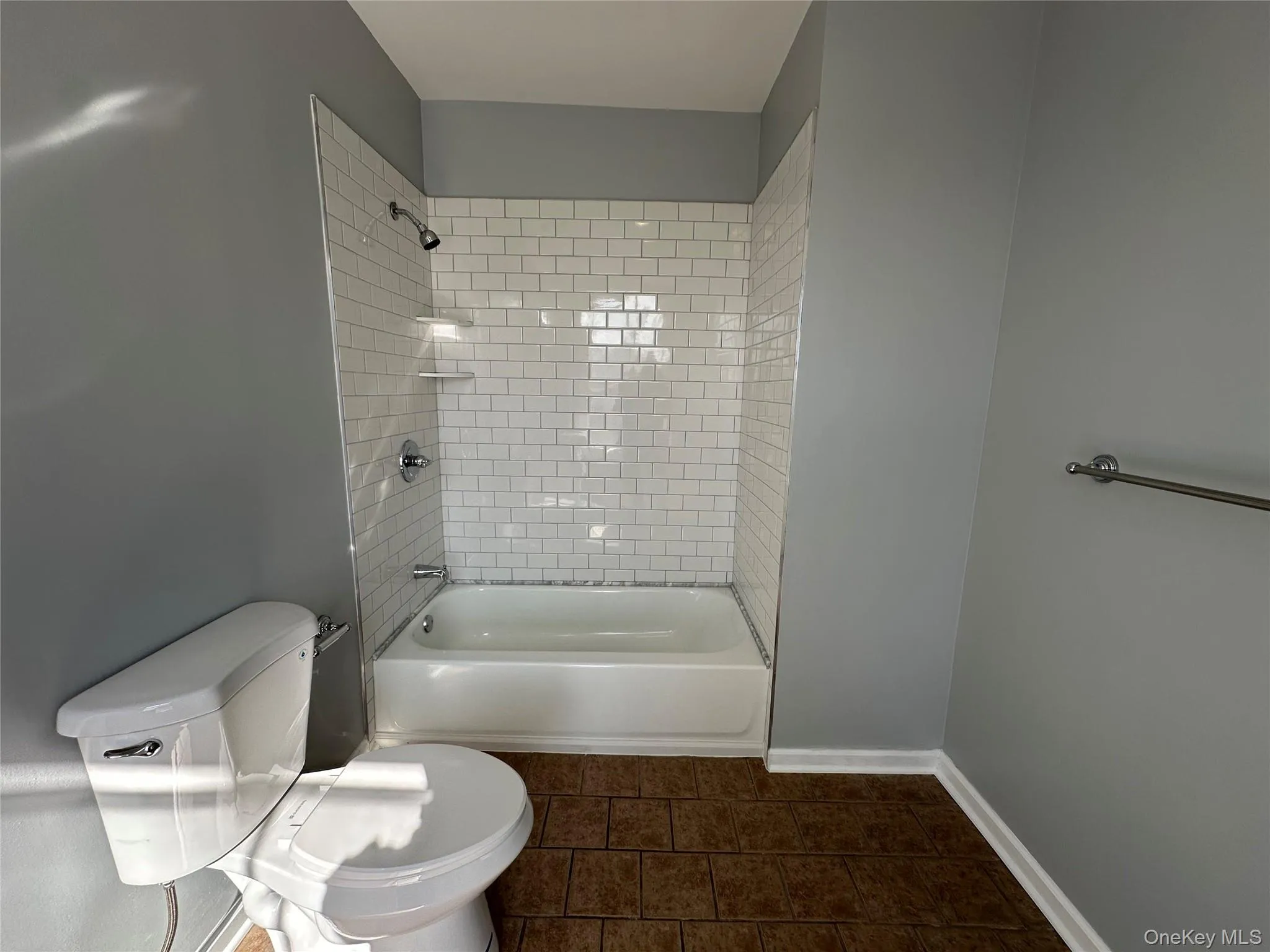 Bathroom featuring tiled shower / bath combo and toilet Bathroom featuring tiled shower / bath combo and toilet