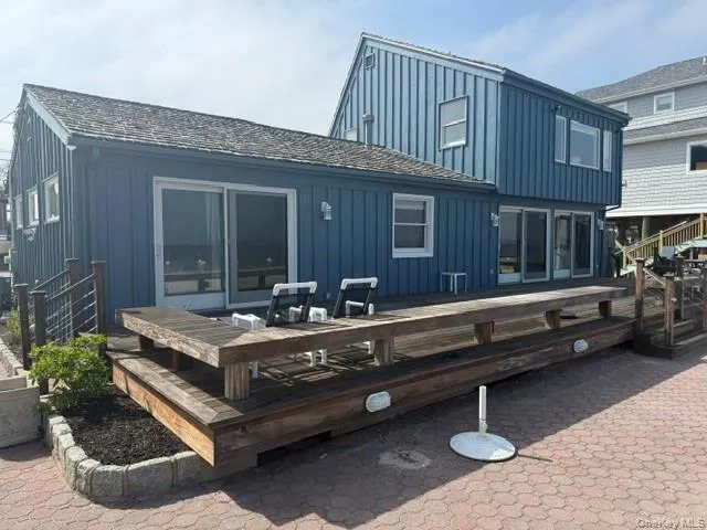 Back of house featuring a wooden deck and board and batten siding Back of house featuring a wooden deck and board and batten siding