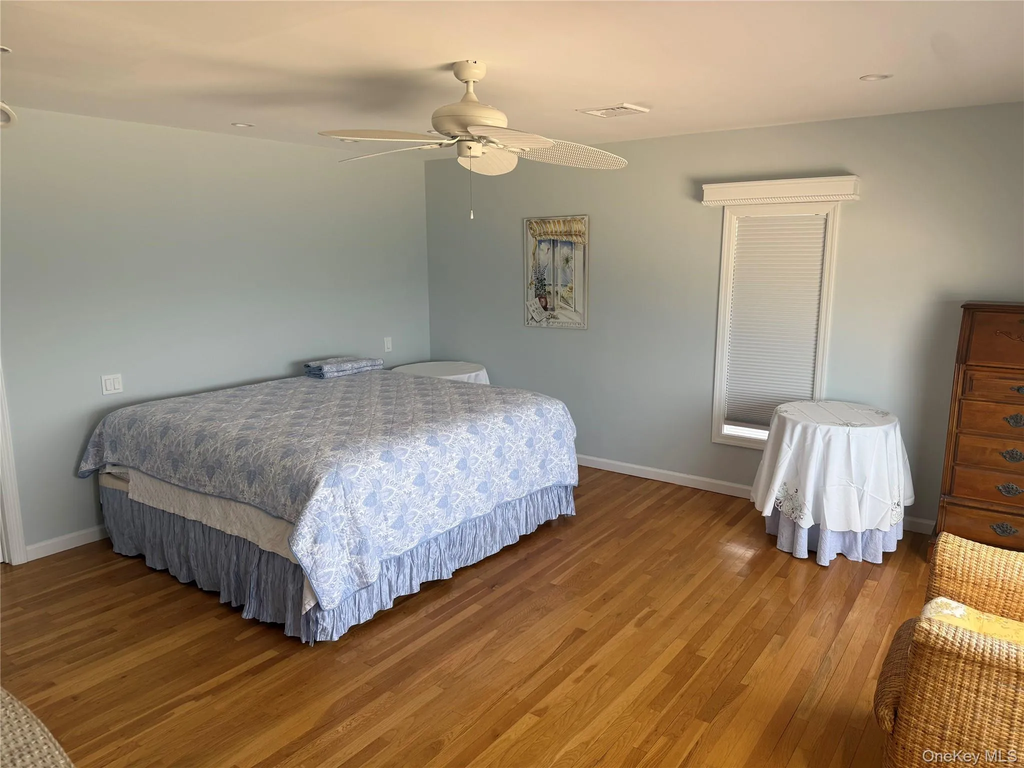 Bedroom featuring baseboards, a ceiling fan, visible vents, and wood finished floors Bedroom featuring baseboards, a ceiling fan, visible vents, and wood finished floors