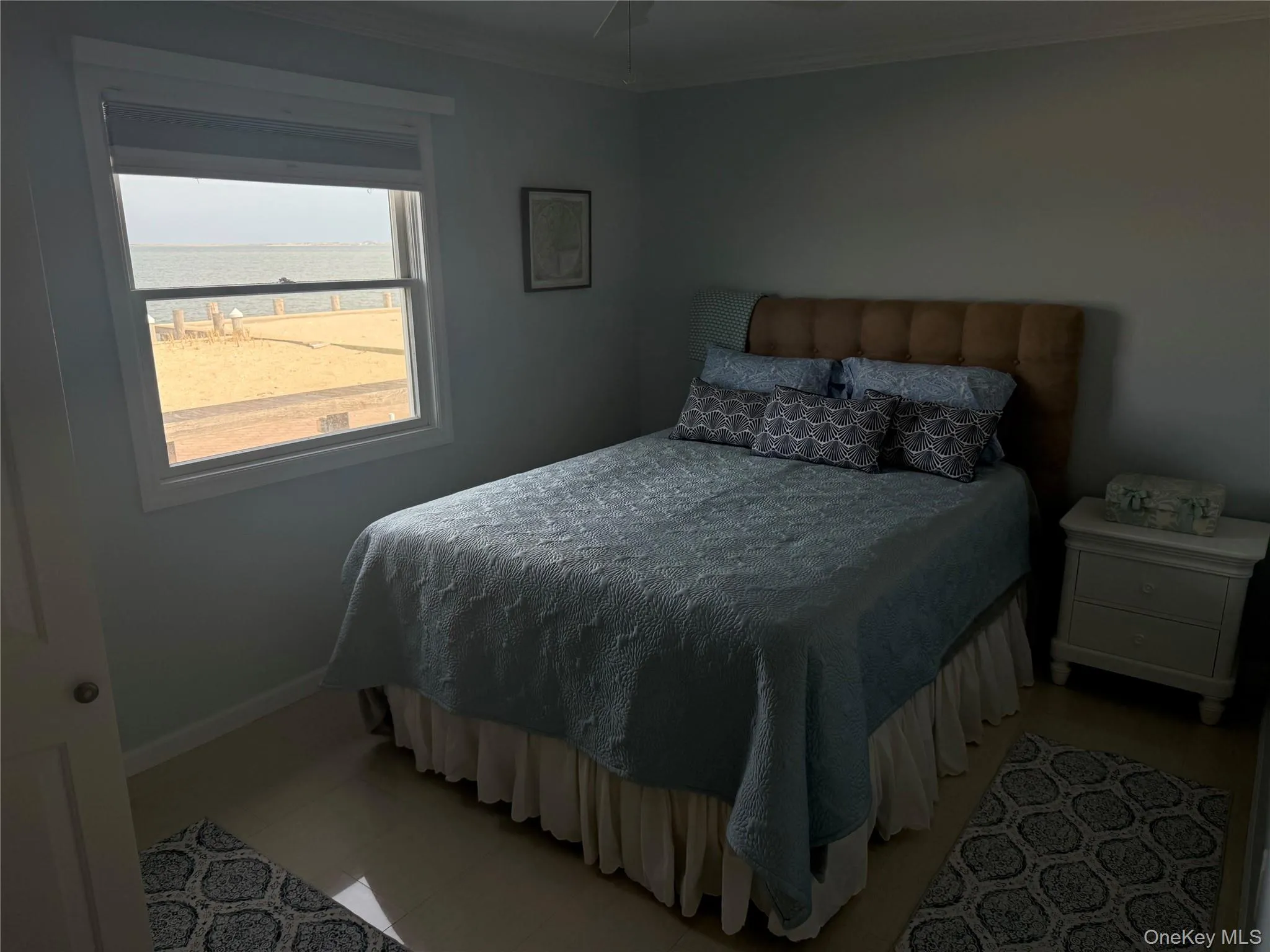 Bedroom featuring a water view, baseboards, and ornamental molding Bedroom featuring a water view, baseboards, and ornamental molding