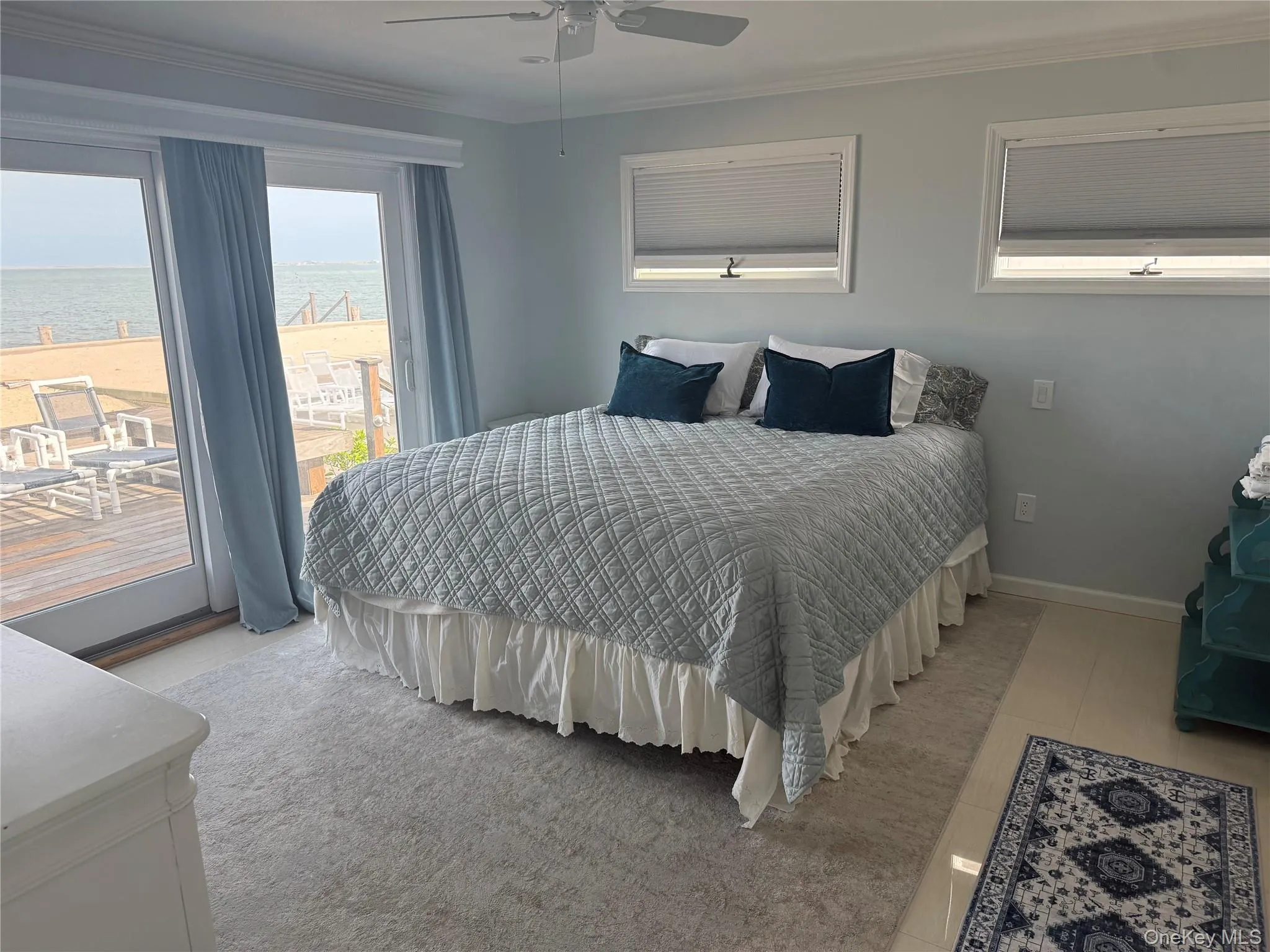 Bedroom with a ceiling fan, ornamental molding, a water view, and baseboards Bedroom with a ceiling fan, ornamental molding, a water view, and baseboards