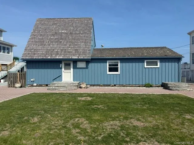 View of front of home featuring a front yard and board and batten siding View of front of home featuring a front yard and board and batten siding