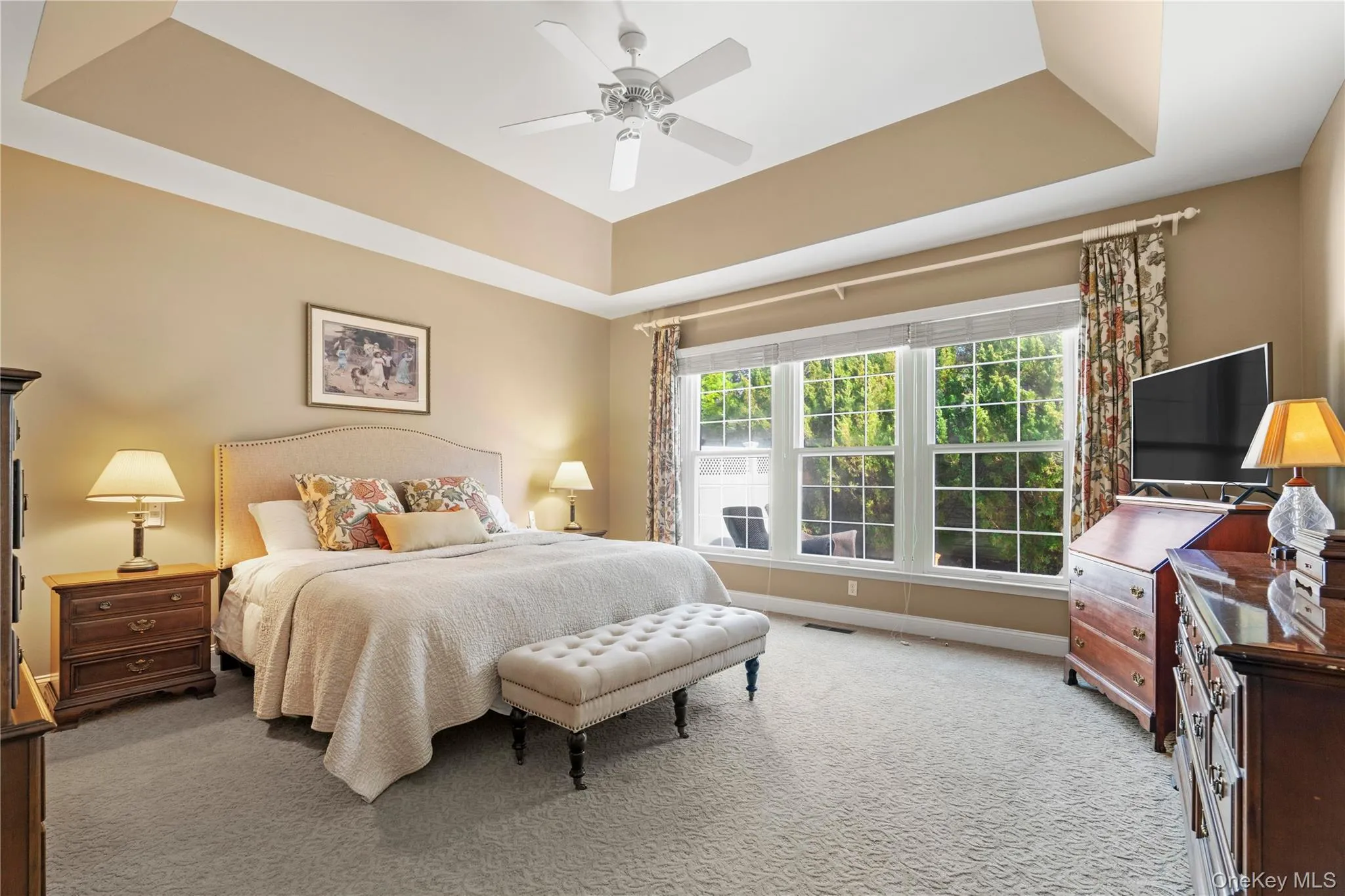 1st Floor primary bed w tray ceilings and rear yard views. 1st Floor primary bed w tray ceilings and rear yard views.