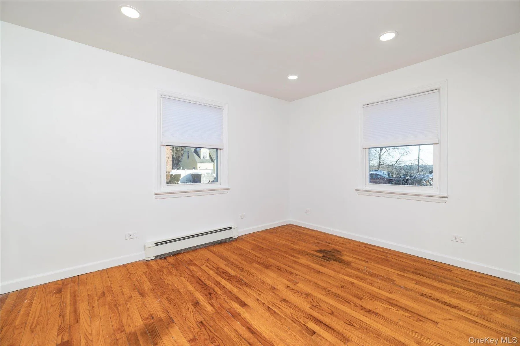 Spare room featuring a baseboard radiator, light wood-style flooring, and recessed lighting Spare room featuring a baseboard radiator, light wood-style flooring, and recessed lighting