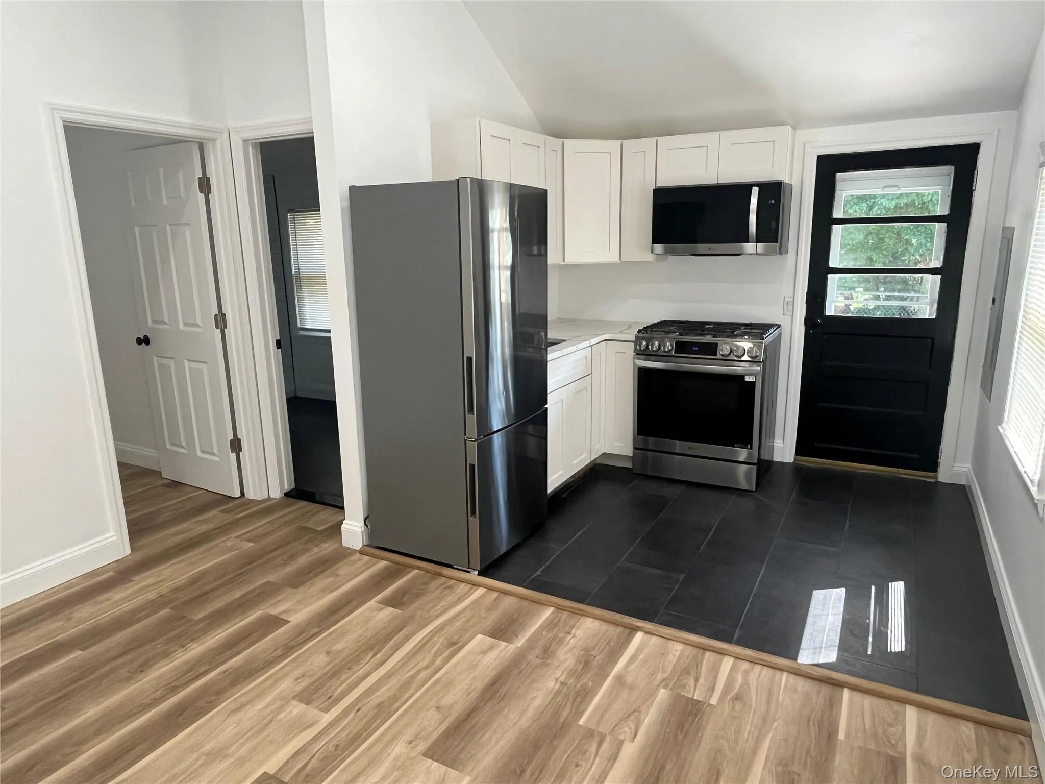 View from Living Room into Kitchen with Stainless Steel Appliances and door to rear Deck View from Living Room into Kitchen with Stainless Steel Appliances and door to rear Deck