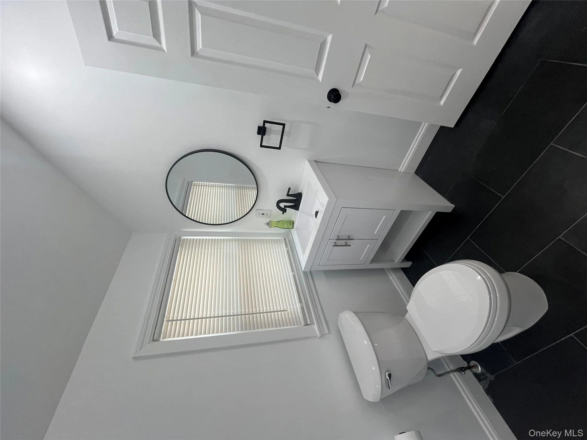 Bathroom with vanity and dark tile patterned flooring Bathroom with vanity and dark tile patterned flooring