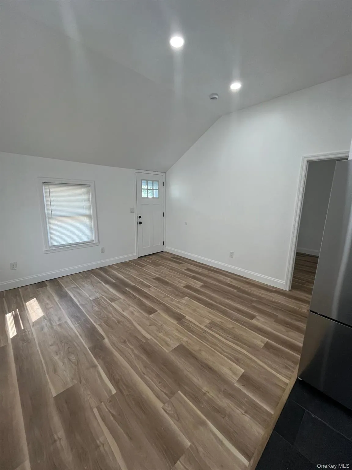 Living room featuring vaulted ceiling, dark wood-type flooring, and recessed lighting Living room featuring vaulted ceiling, dark wood-type flooring, and recessed lighting