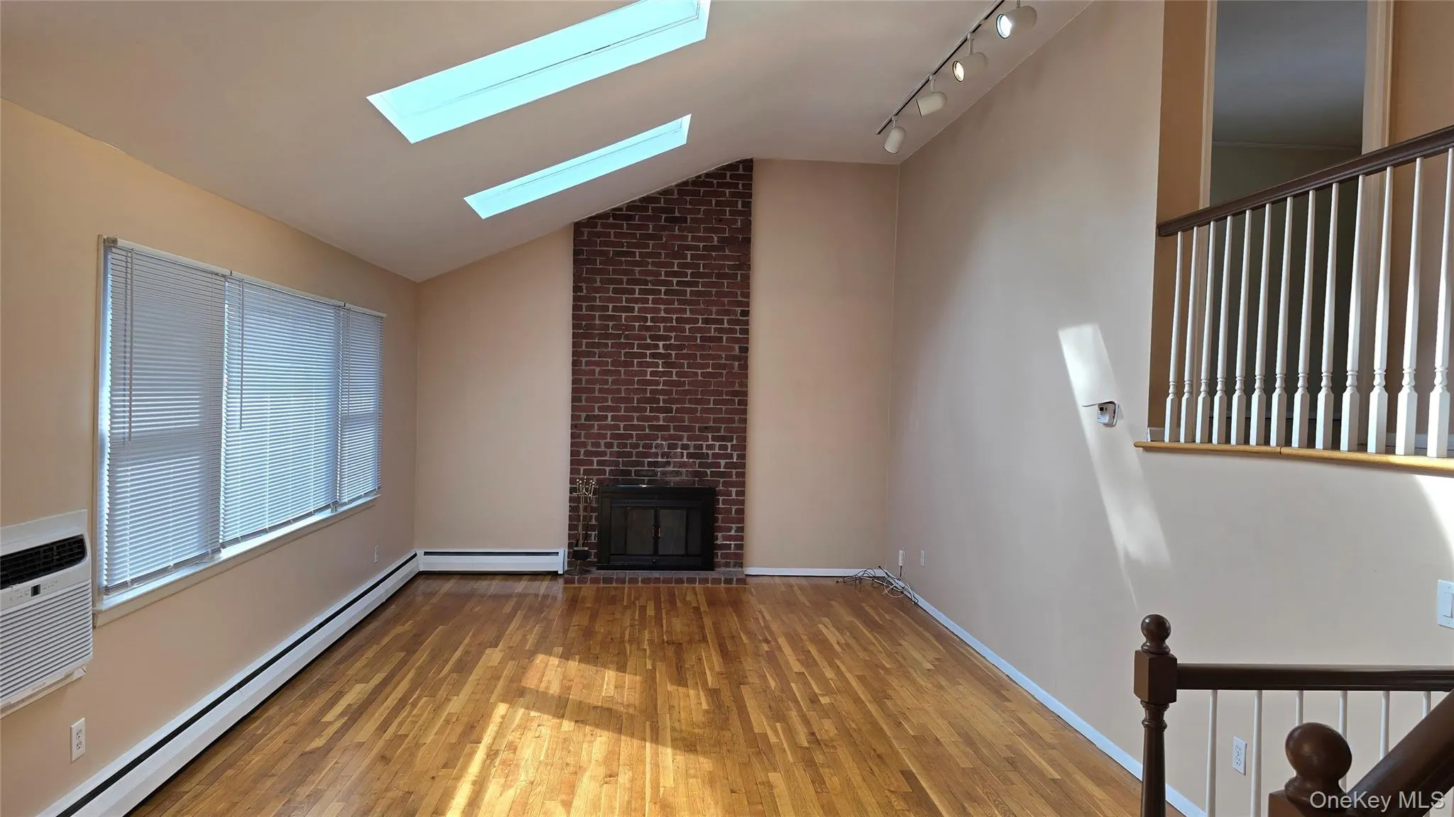 Living Room with lofted ceiling, hardwood floors and skylights Living Room with lofted ceiling, hardwood floors and skylights