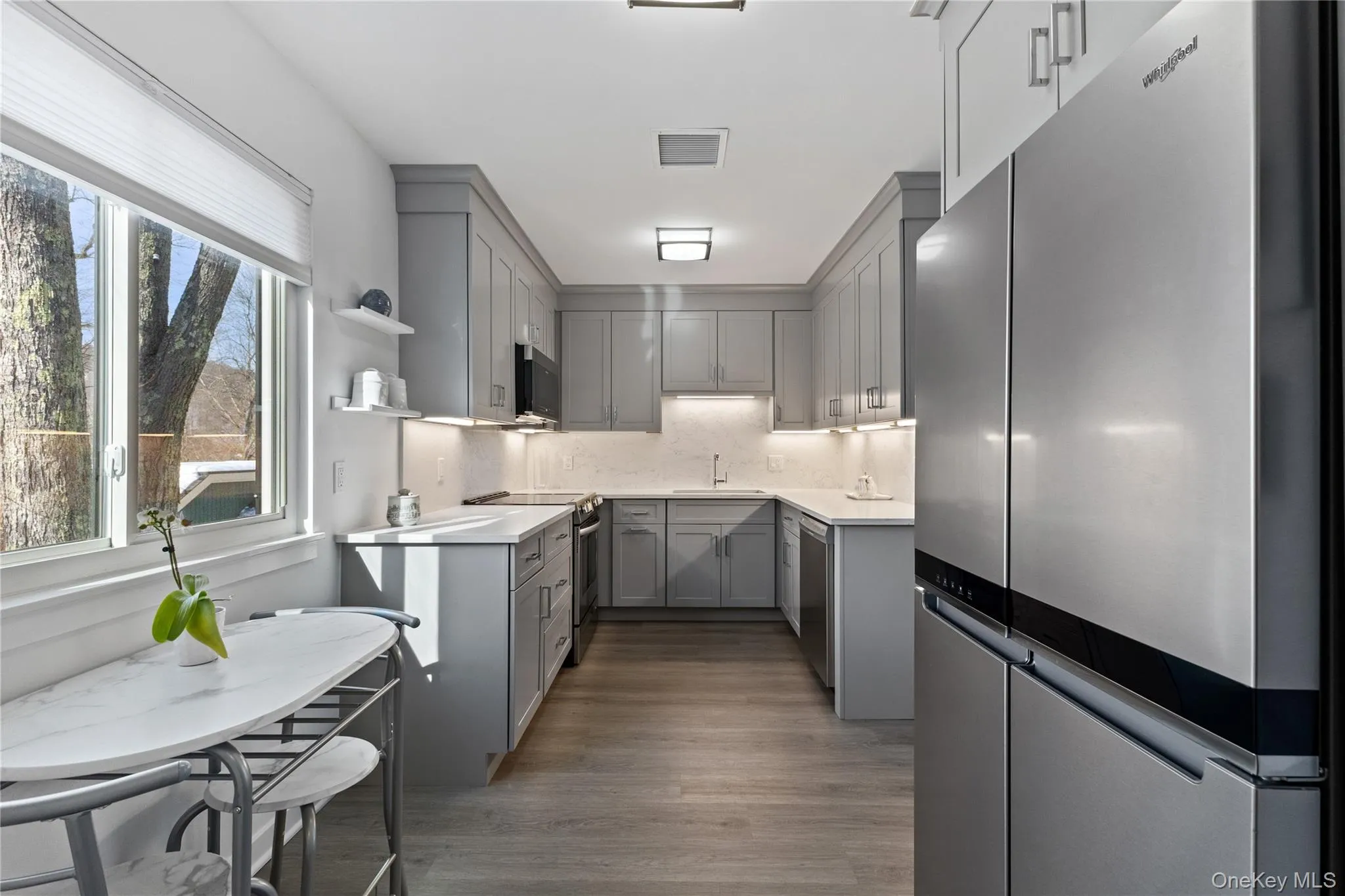 Kitchen with high-end stainless steel appliances. Under-cabinet lighting. Kitchen with high-end stainless steel appliances. Under-cabinet lighting.
