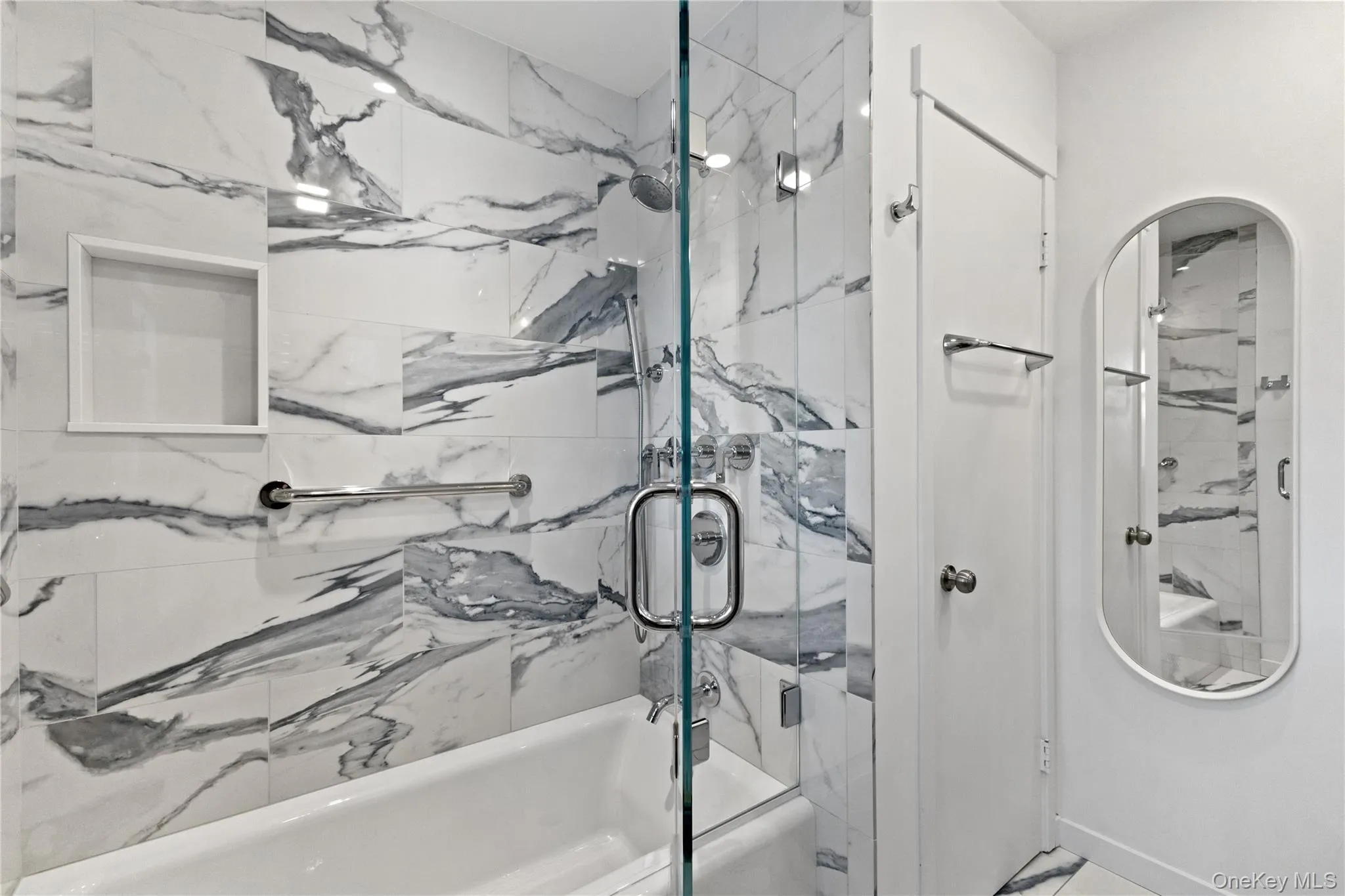 Kohler tub with porcelain tile surround and grab-bars. The linen closet is nice to have in the primary bathroom. Kohler tub with porcelain tile surround and grab-bars. The linen closet is nice to have in the primary bathroom.