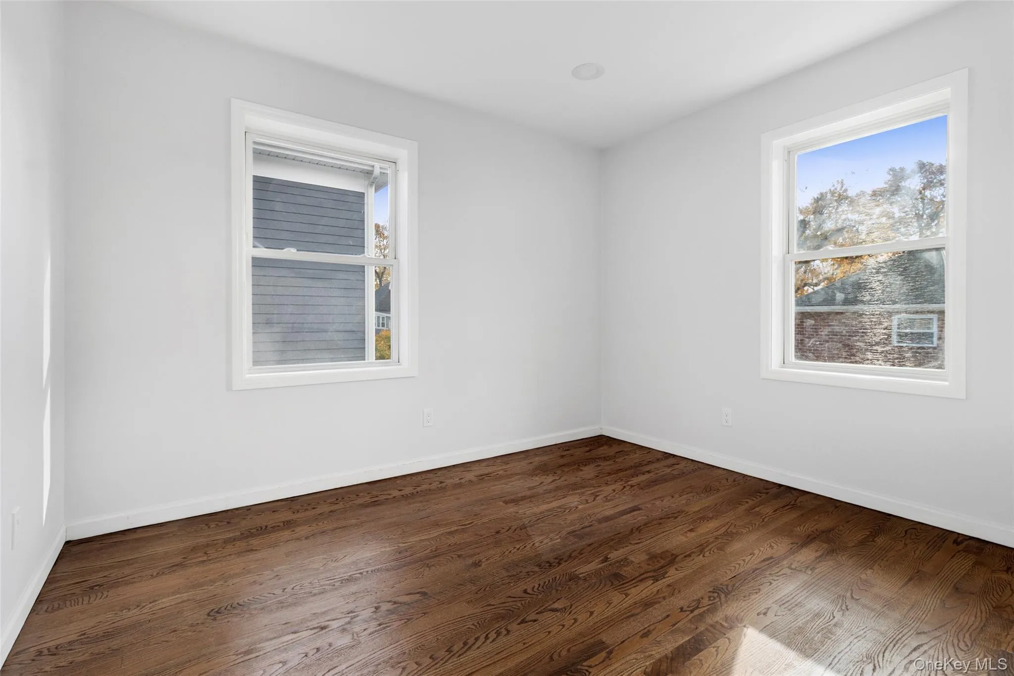 Unfurnished room with dark wood-style flooring Unfurnished room with dark wood-style flooring