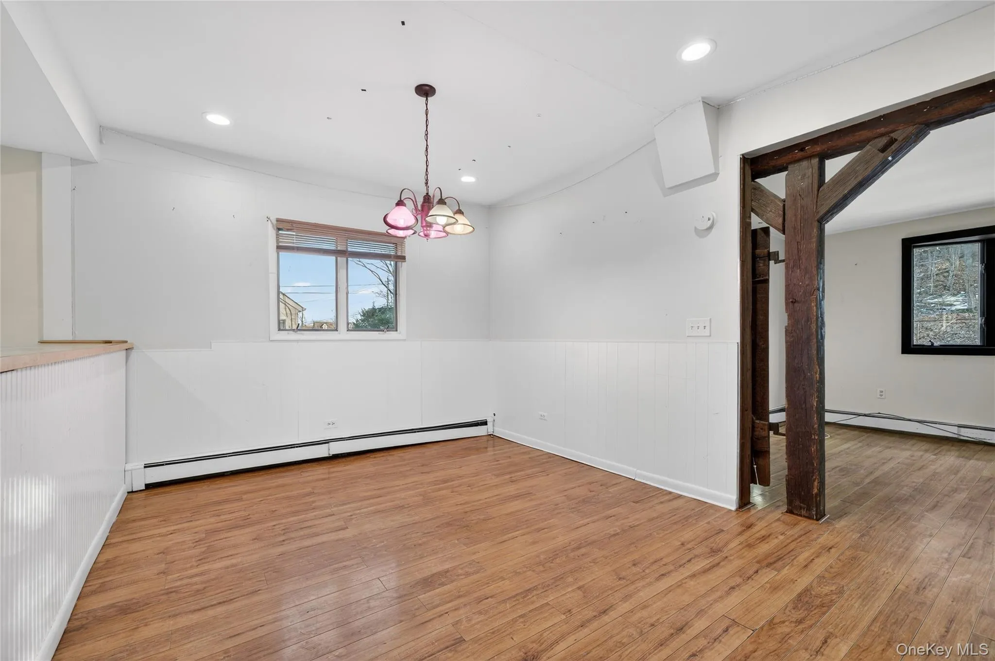 Spare room featuring a wainscoted wall, light wood finished floors, baseboard heating, a chandelier, and recessed lighting Spare room featuring a wainscoted wall, light wood finished floors, baseboard heating, a chandelier, and recessed lighting