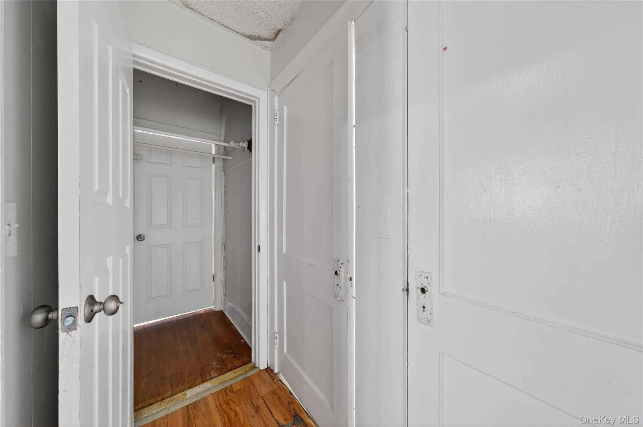 Corridor with wood finished floors and a textured ceiling Corridor with wood finished floors and a textured ceiling