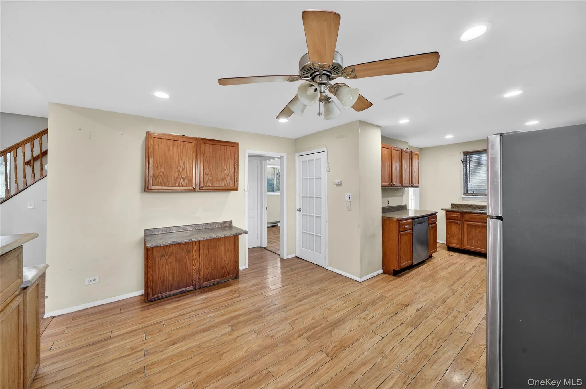 Kitchen with appliances with stainless steel finishes, brown cabinets, ceiling fan, light wood finished floors, and recessed lighting Kitchen with appliances with stainless steel finishes, brown cabinets, ceiling fan, light wood finished floors, and recessed lighting