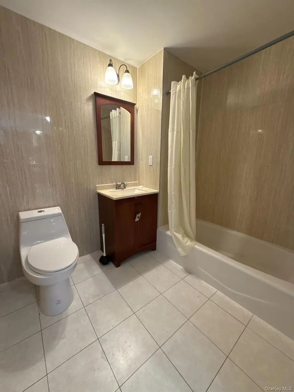 Full bathroom featuring vanity, shower / bath combo, and light tile patterned floors Full bathroom featuring vanity, shower / bath combo, and light tile patterned floors