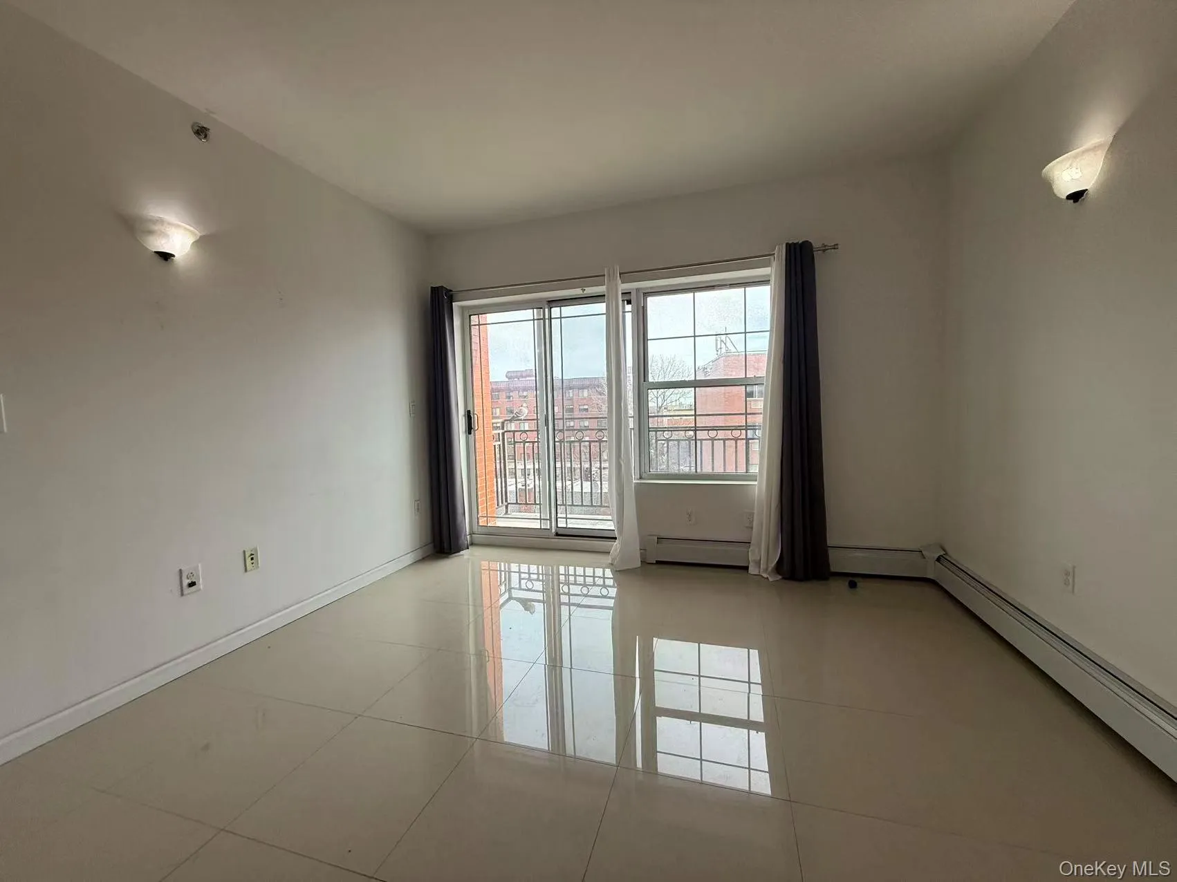 Unfurnished room with a baseboard radiator and light tile patterned floors Unfurnished room with a baseboard radiator and light tile patterned floors
