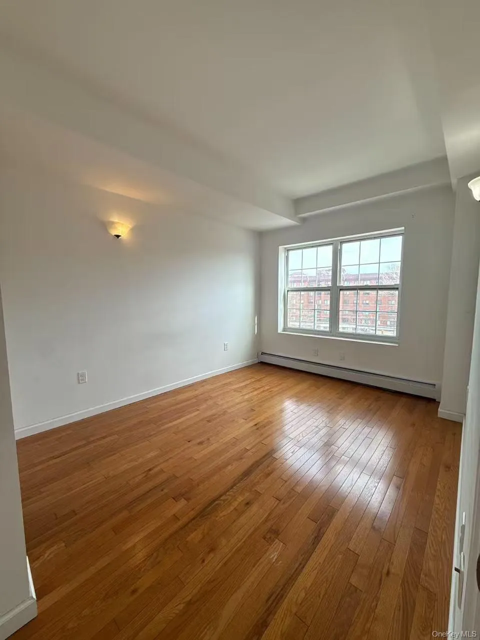 Spare room with baseboard heating and light wood-style flooring Spare room with baseboard heating and light wood-style flooring