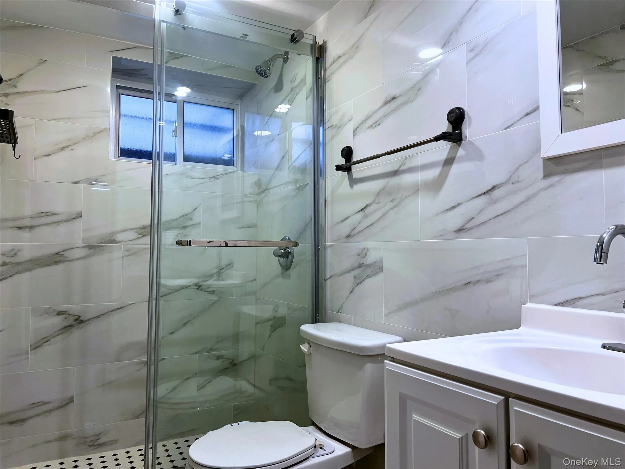 Bathroom with vanity, tile walls, and a marble finish shower Bathroom with vanity, tile walls, and a marble finish shower