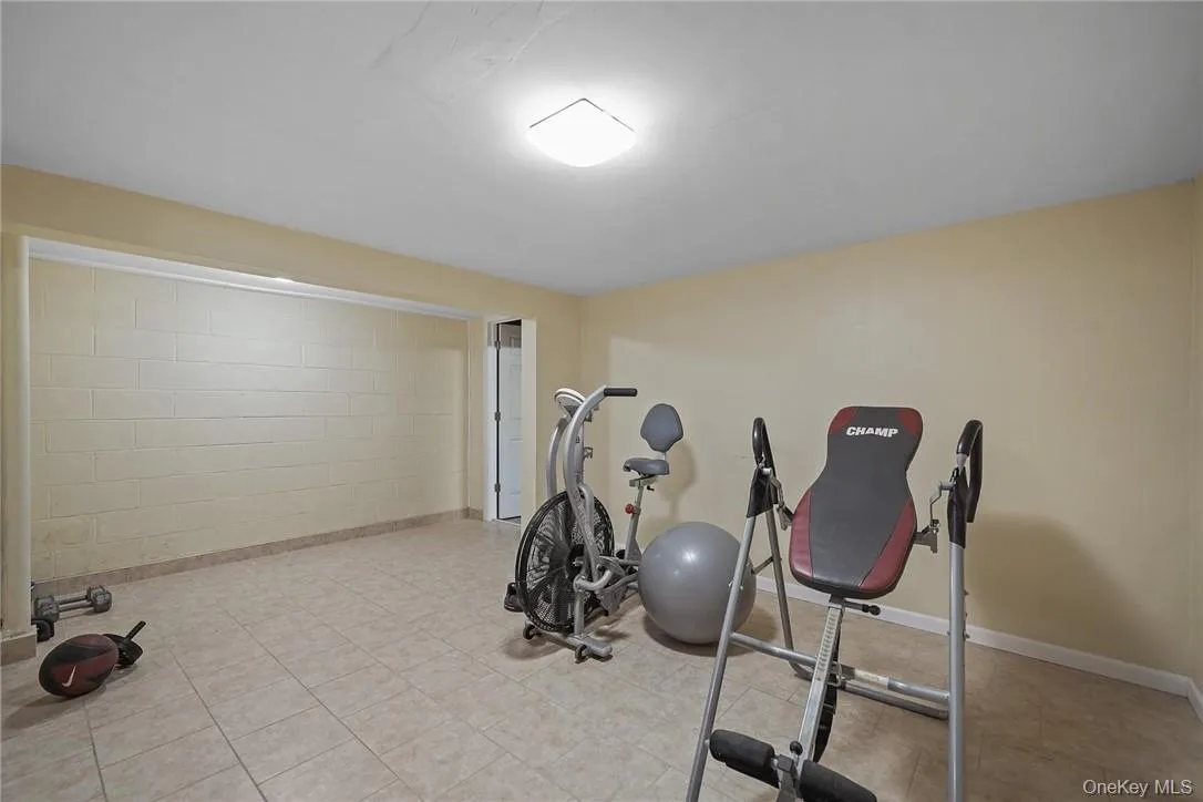 Exercise room featuring concrete block wall and baseboards Exercise room featuring concrete block wall and baseboards