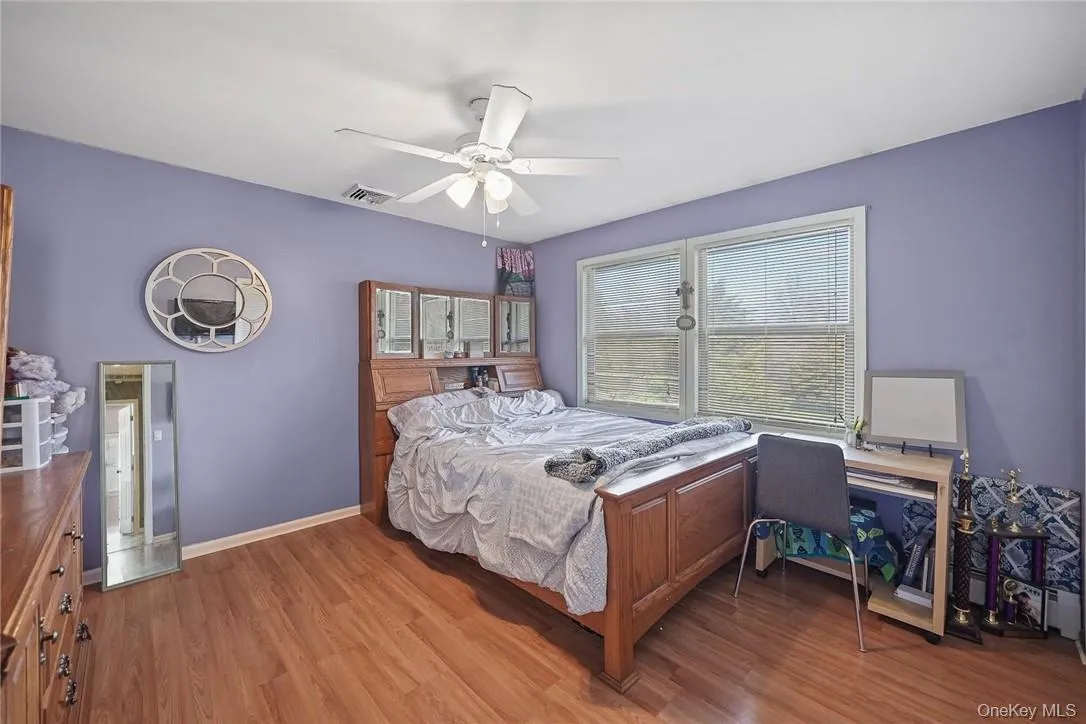 Bedroom with wood finished floors and ceiling fan Bedroom with wood finished floors and ceiling fan
