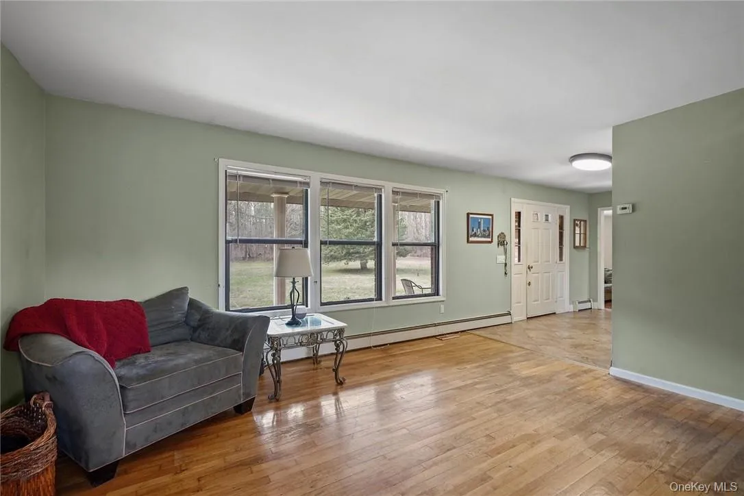 Living area with a baseboard radiator, light wood-style flooring, and baseboard heating Living area with a baseboard radiator, light wood-style flooring, and baseboard heating