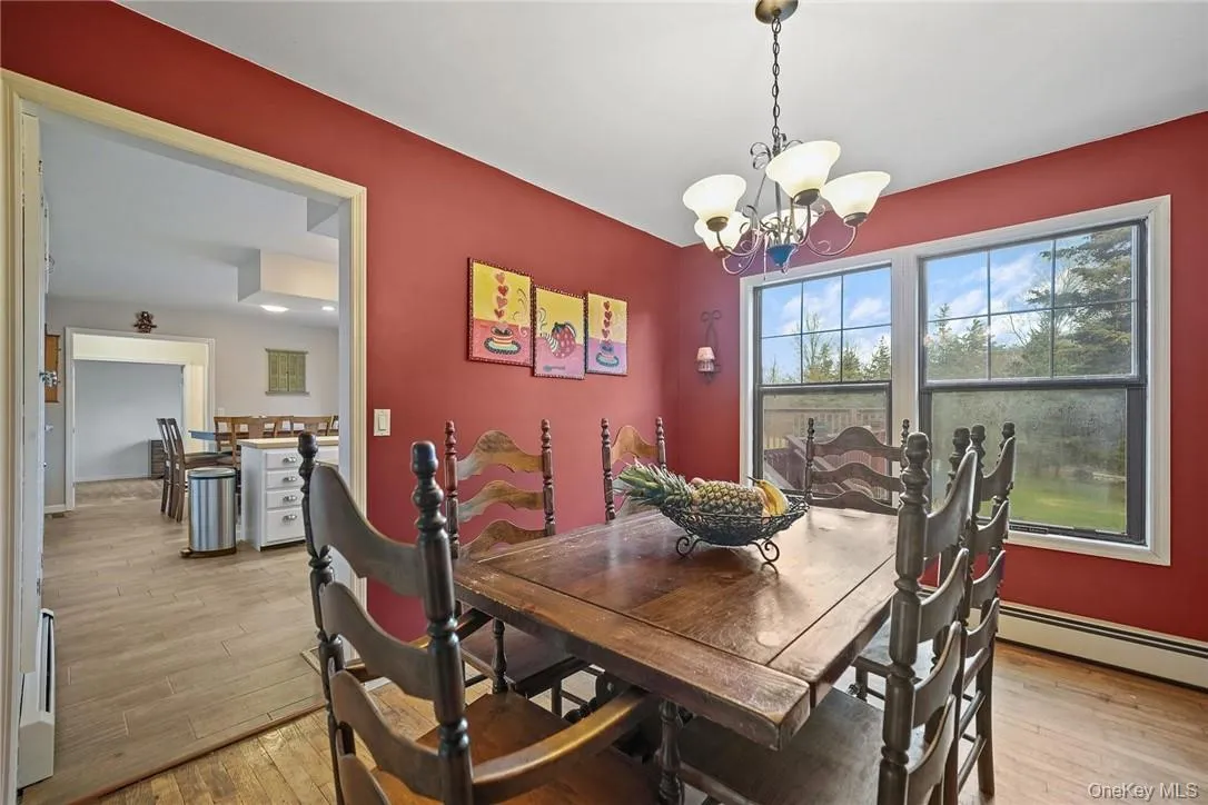 Dining space featuring light wood-type flooring and a chandelier Dining space featuring light wood-type flooring and a chandelier