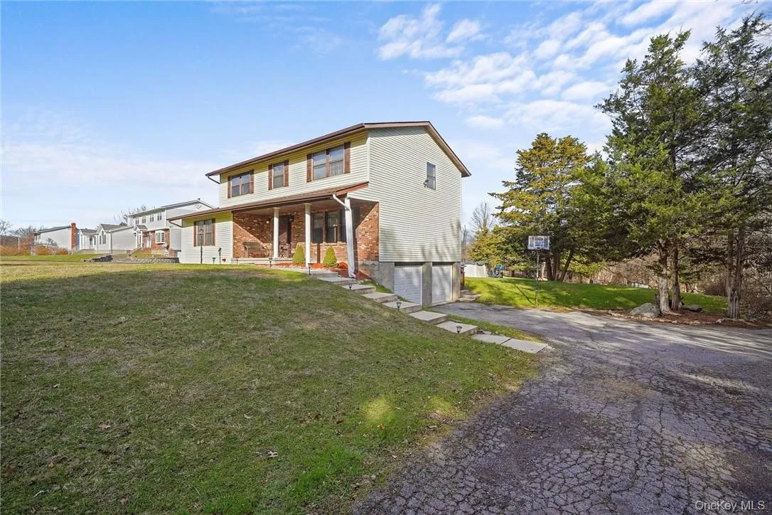 View of front facade featuring a front lawn, asphalt driveway, and an attached garage View of front facade featuring a front lawn, asphalt driveway, and an attached garage