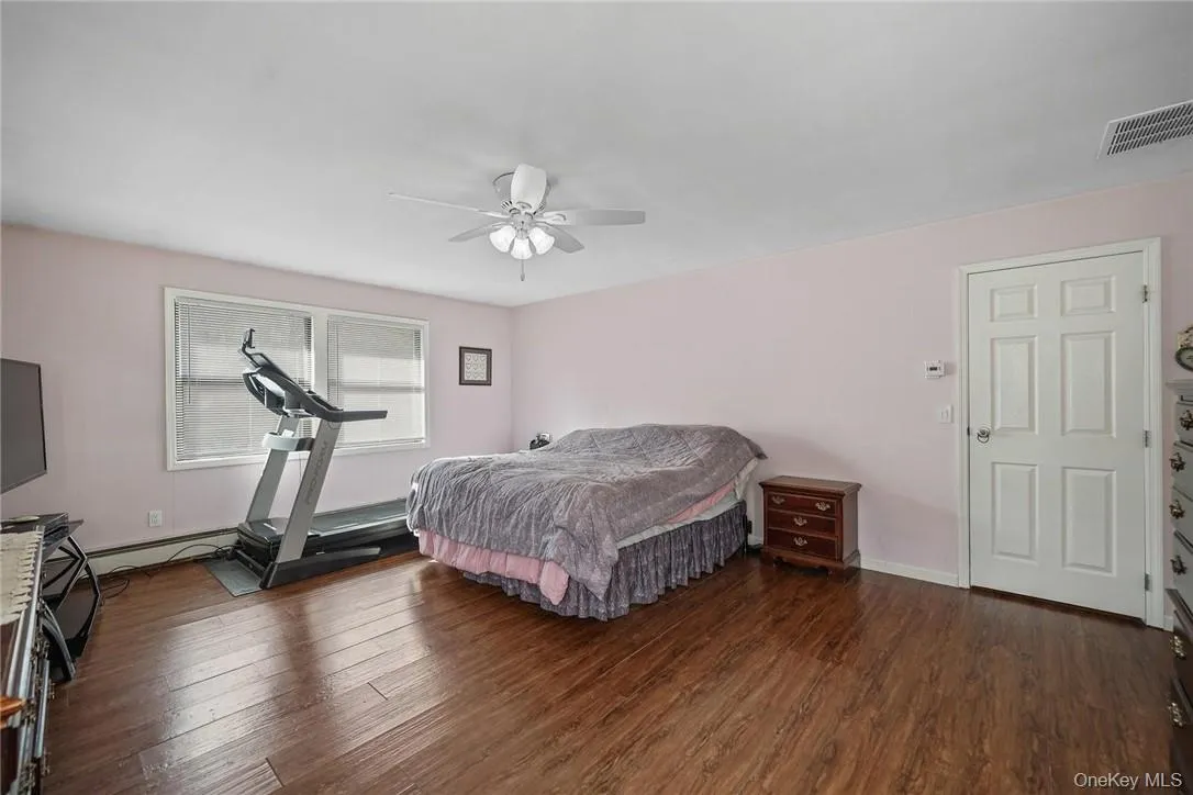 Bedroom with dark wood finished floors and ceiling fan Bedroom with dark wood finished floors and ceiling fan