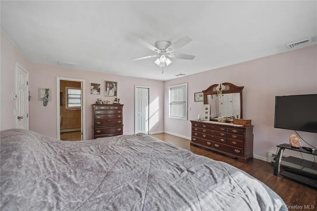 Bedroom featuring wood finished floors, a closet, multiple windows, and a ceiling fan Bedroom featuring wood finished floors, a closet, multiple windows, and a ceiling fan