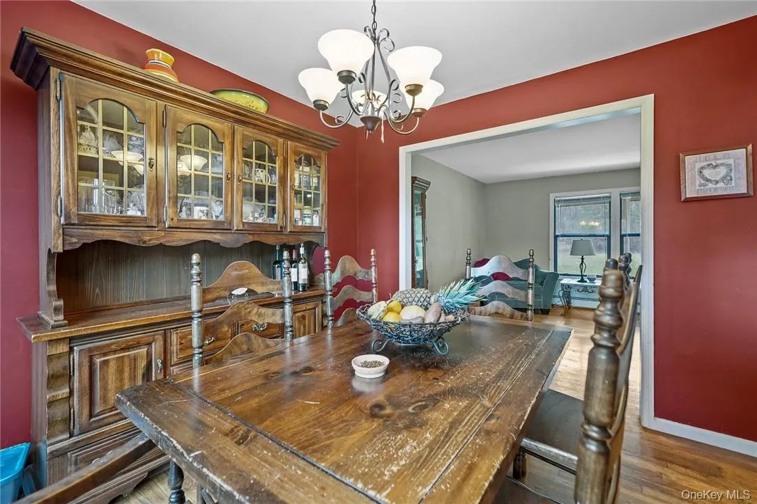 Dining area with a chandelier and dark wood-style floors Dining area with a chandelier and dark wood-style floors