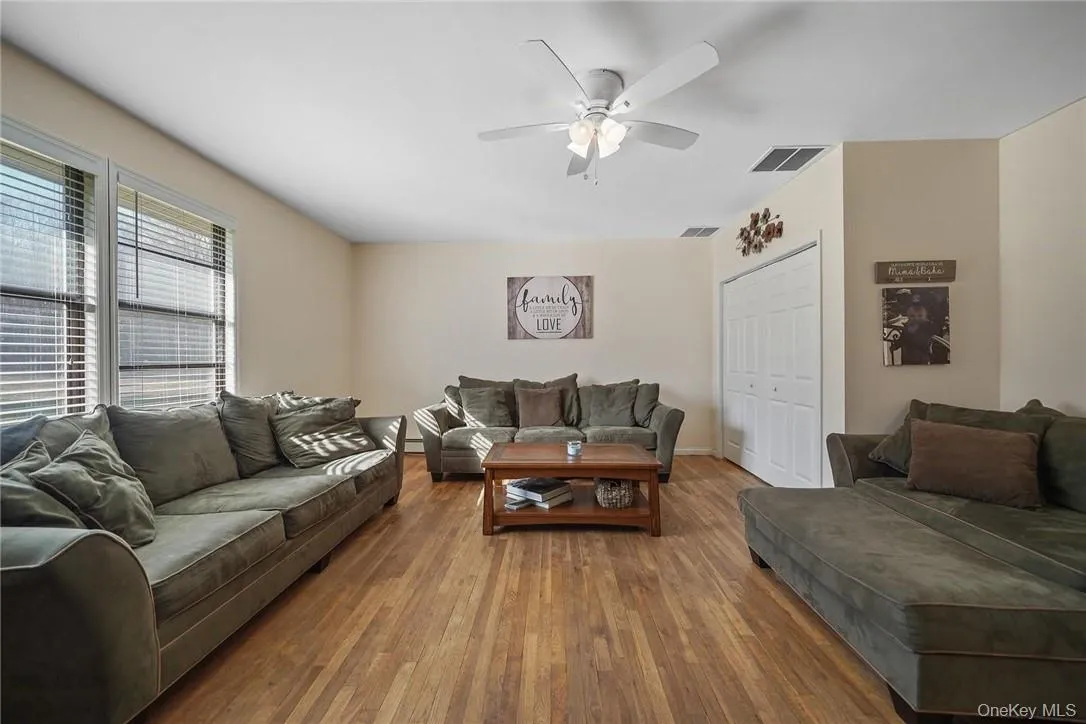 Living room with hardwood / wood-style floors and a ceiling fan Living room with hardwood / wood-style floors and a ceiling fan