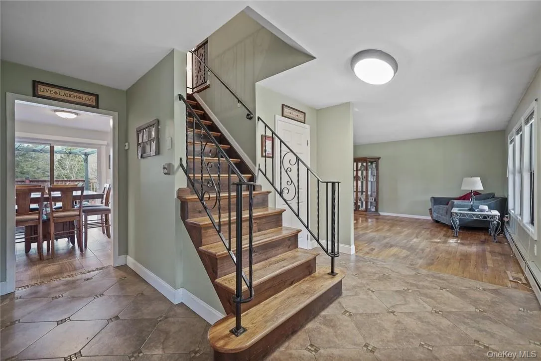 Stairs featuring plenty of natural light and a baseboard radiator Stairs featuring plenty of natural light and a baseboard radiator