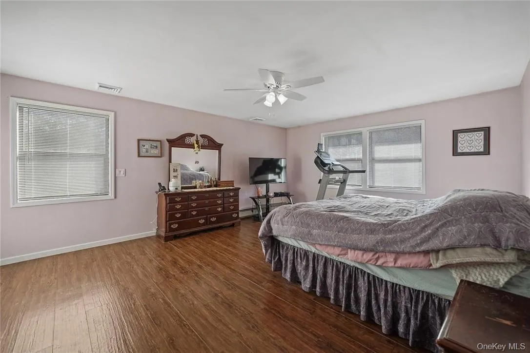 Bedroom featuring hardwood / wood-style flooring and a ceiling fan Bedroom featuring hardwood / wood-style flooring and a ceiling fan