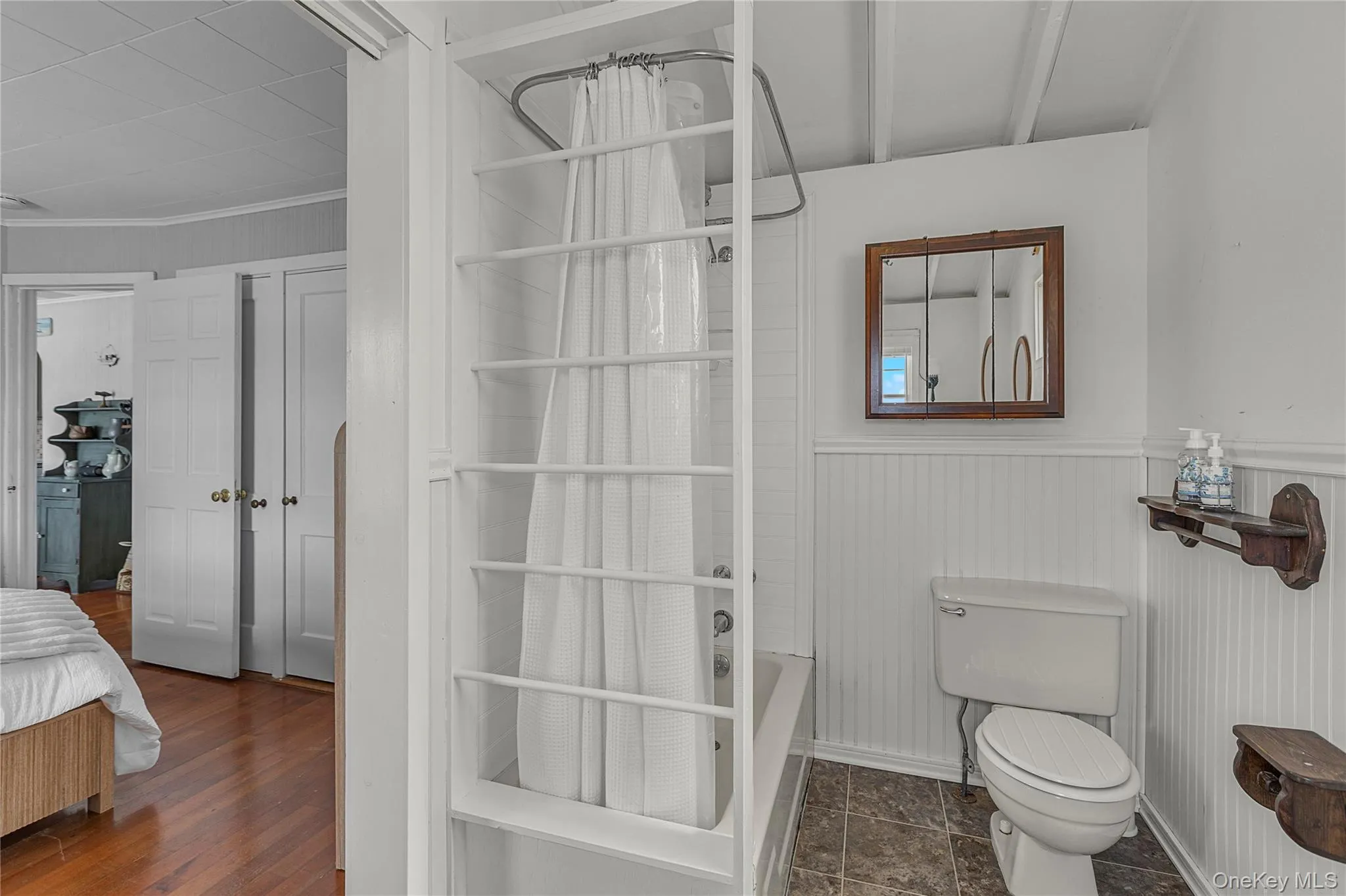 Full bathroom with toilet and wainscoting Full bathroom with toilet and wainscoting