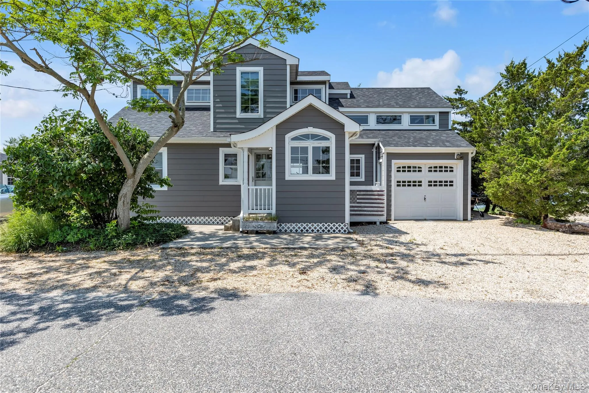 View of front of home featuring gravel driveway, roof with shingles, entry steps, and a garage View of front of home featuring gravel driveway, roof with shingles, entry steps, and a garage
