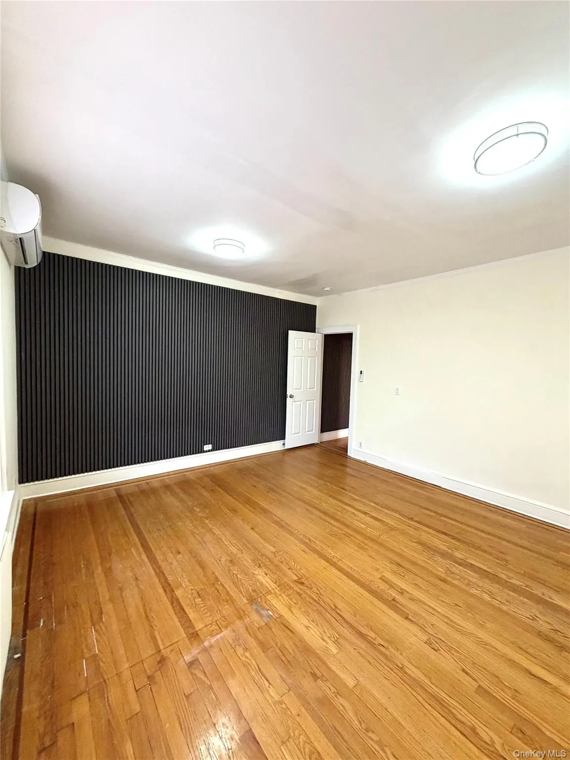 Huge bedroom or living room with light wood finished floors and a wall mounted AC Huge bedroom or living room with light wood finished floors and a wall mounted AC