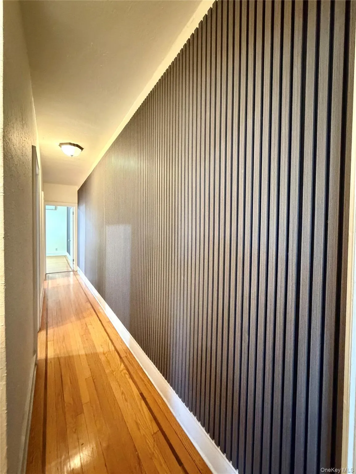 Hallway featuring wood-type flooring and baseboards Hallway featuring wood-type flooring and baseboards