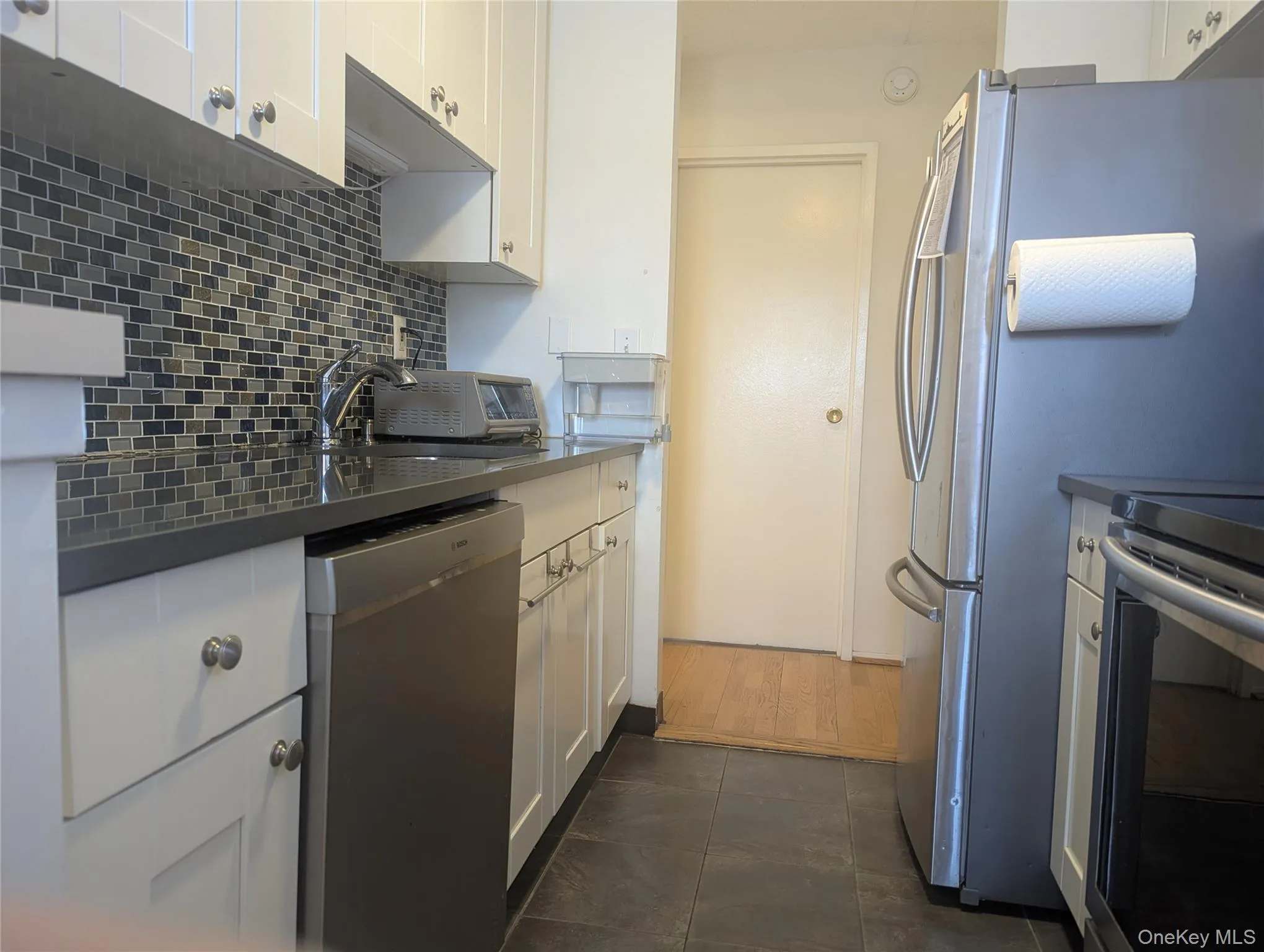 Updated kitchen with plentiful white shaker cabinets and stainless steel appliances Updated kitchen with plentiful white shaker cabinets and stainless steel appliances