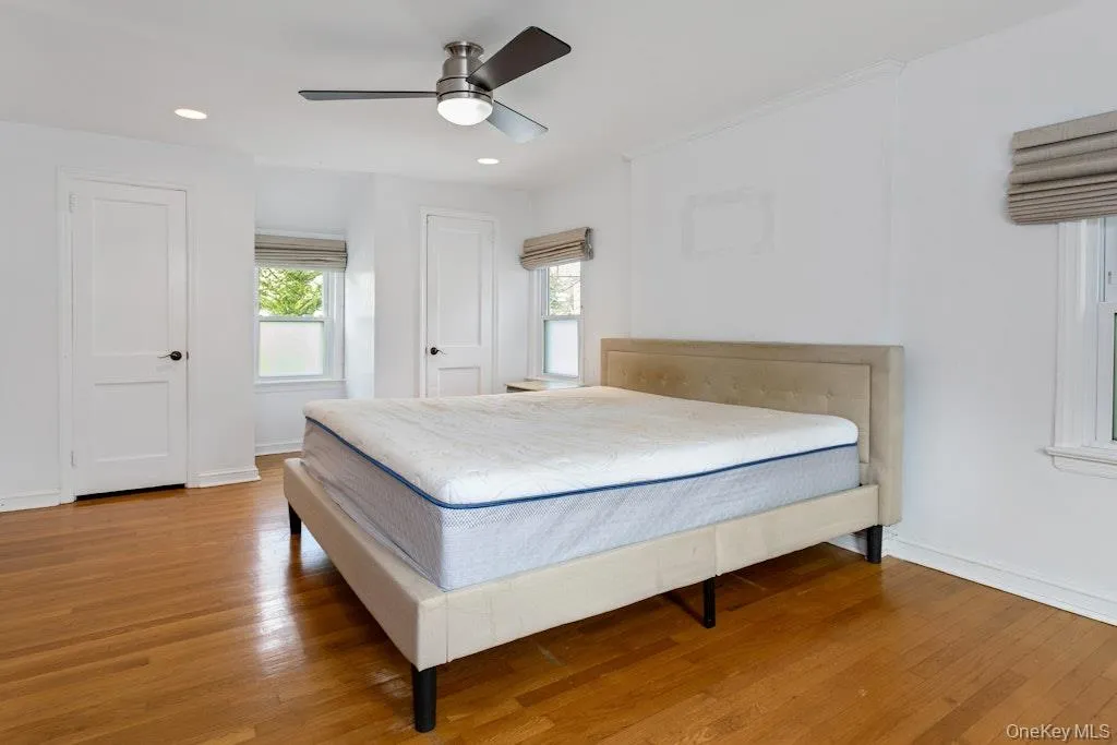 Bedroom with wood flooring, a ceiling fan, two closets, and recessed lighting. Bedroom with wood flooring, a ceiling fan, two closets, and recessed lighting.