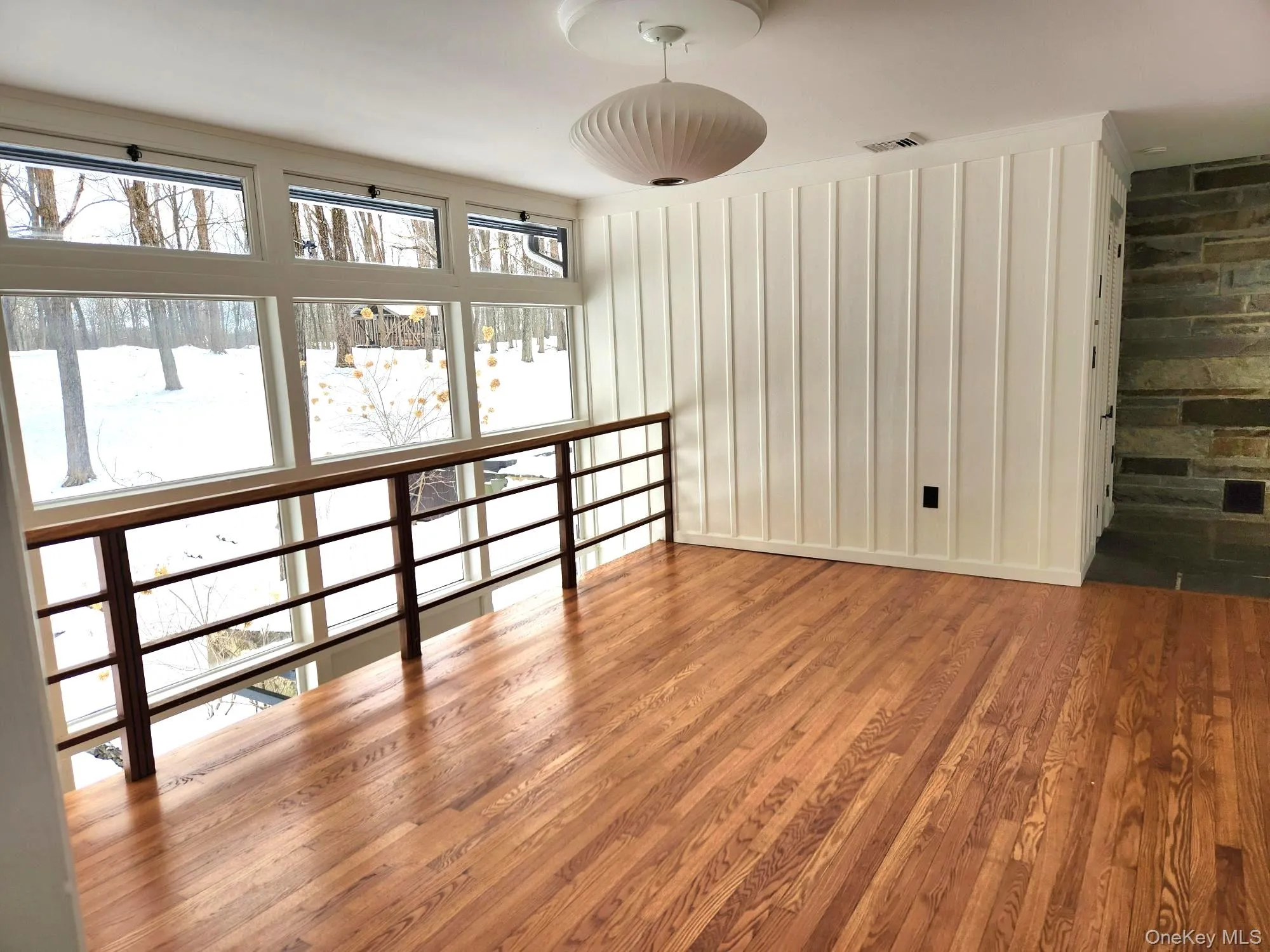 Spare room featuring wood finished floors and baseboards Spare room featuring wood finished floors and baseboards