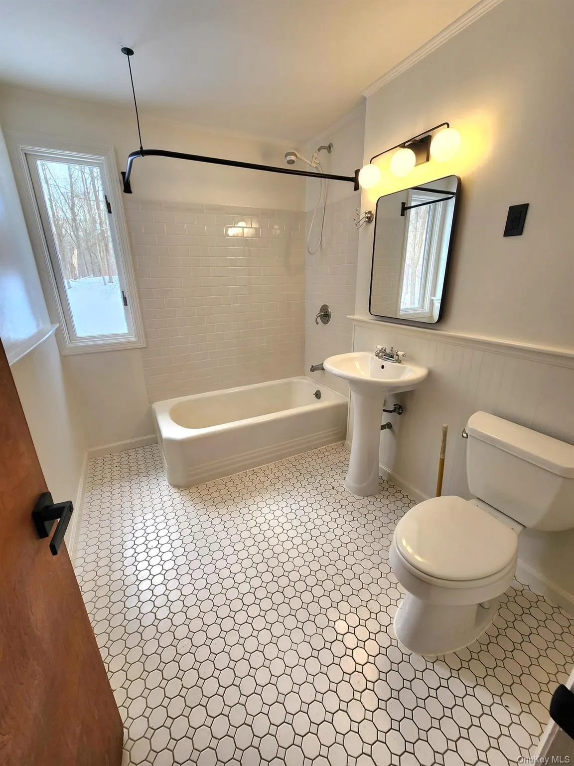 Full bath with washtub / shower combination, a wainscoted wall, and ornamental molding Full bath with washtub / shower combination, a wainscoted wall, and ornamental molding