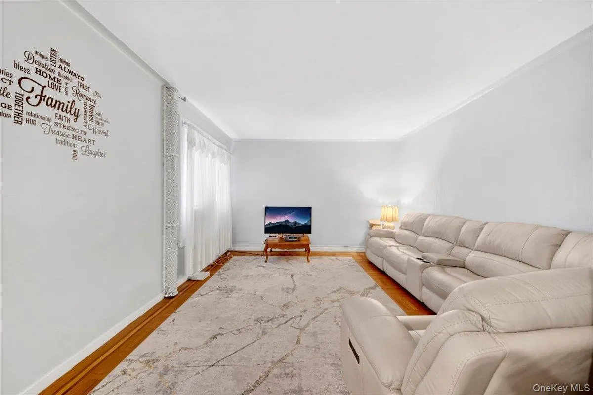 Living room featuring wood finished floors and ornamental molding Living room featuring wood finished floors and ornamental molding