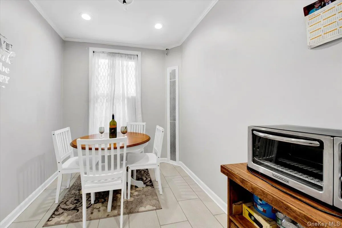 Dining space featuring crown molding, recessed lighting, and light tile patterned floors Dining space featuring crown molding, recessed lighting, and light tile patterned floors