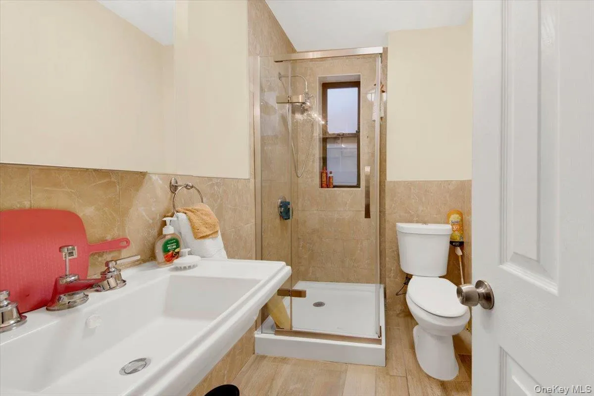 Full bathroom with tile walls and a shower stall Full bathroom with tile walls and a shower stall