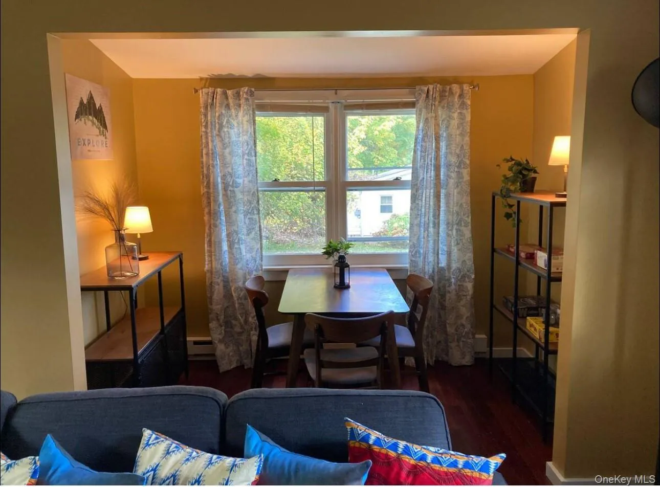 Dining area featuring dark wood finished floors and baseboard heating Dining area featuring dark wood finished floors and baseboard heating