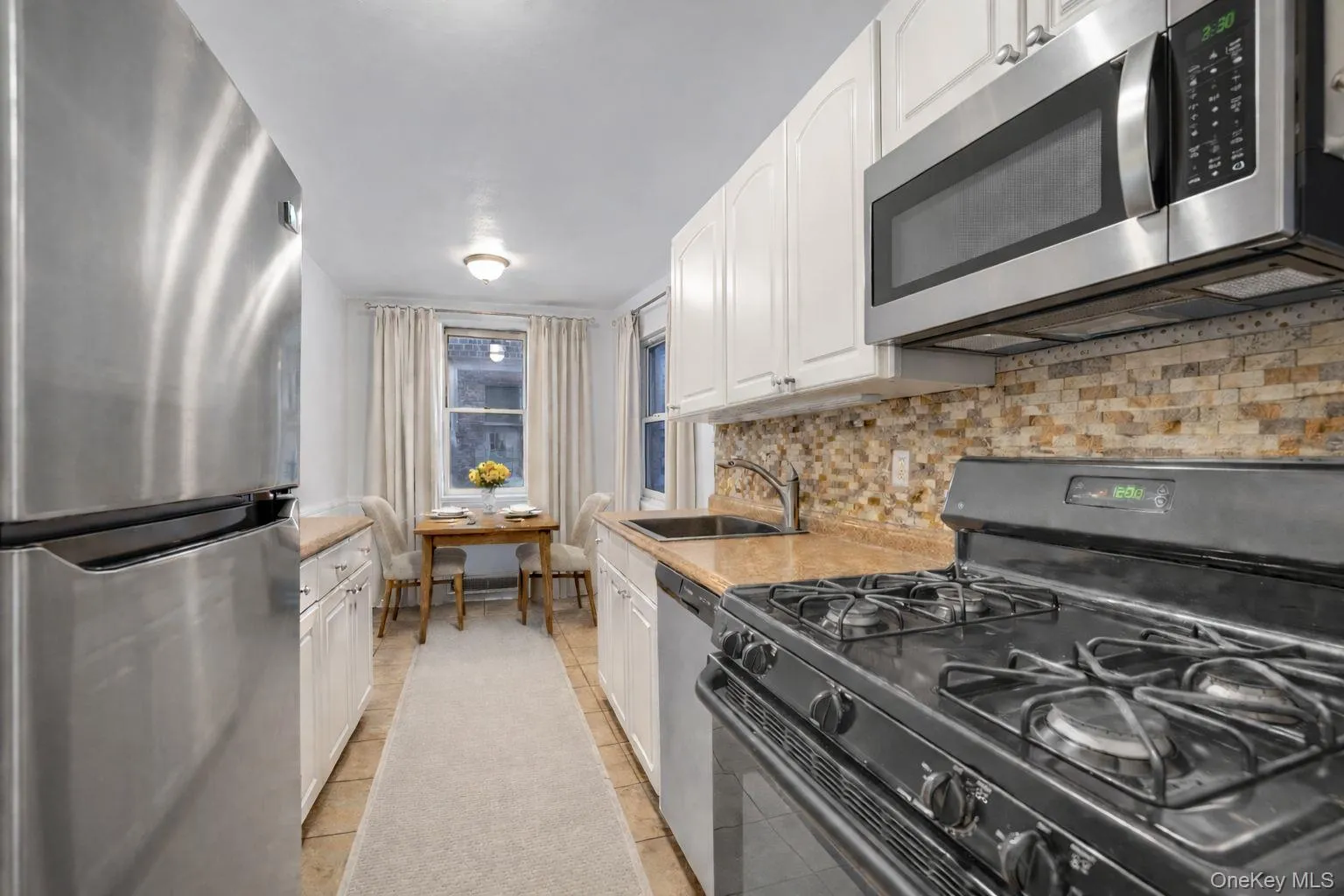 Kitchen with Brand new stainless steel appliances. staged with furnishings Kitchen with Brand new stainless steel appliances. staged with furnishings