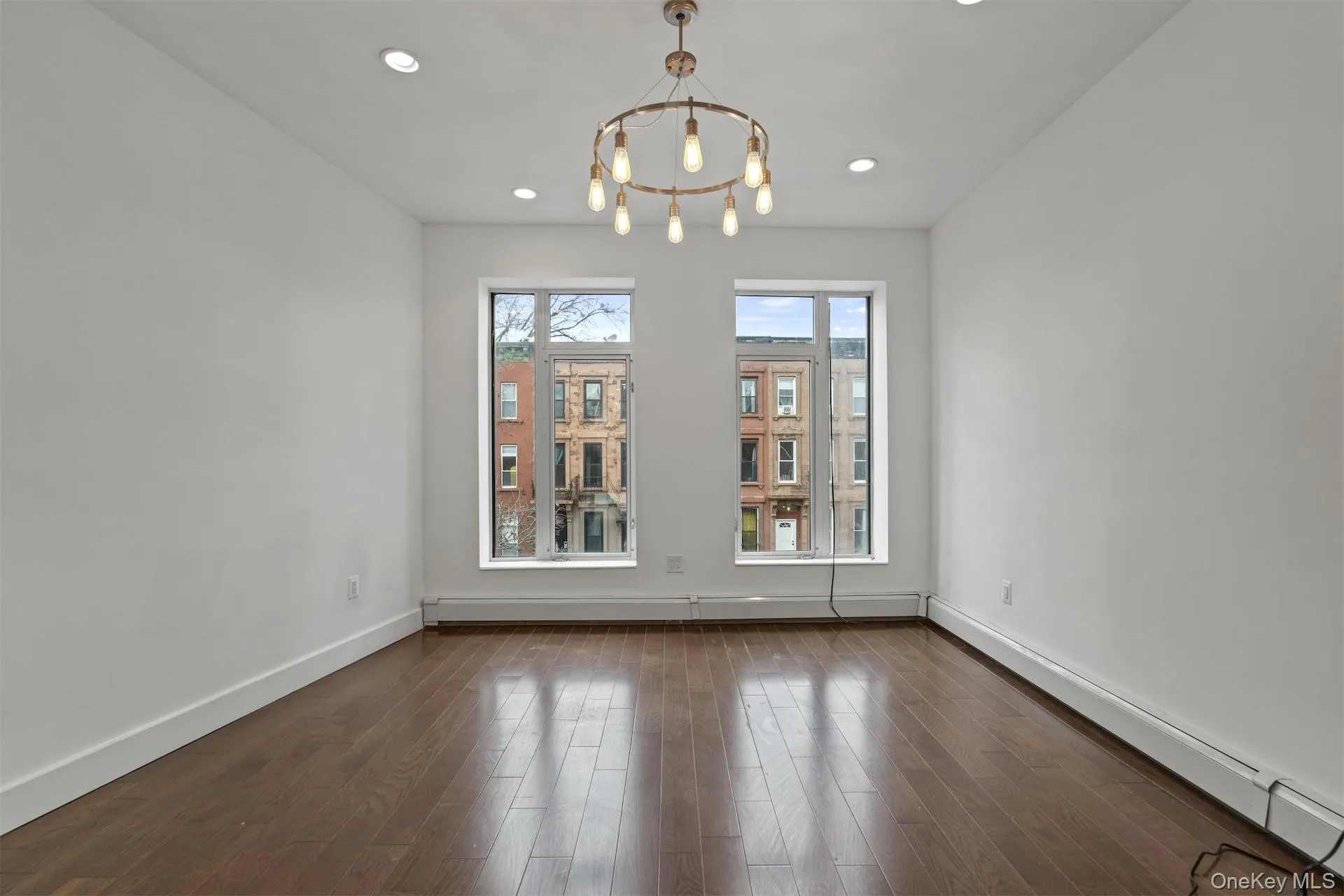 Unfurnished dining area featuring a baseboard heating unit, dark wood-style floors, a chandelier, and recessed lighting Unfurnished dining area featuring a baseboard heating unit, dark wood-style floors, a chandelier, and recessed lighting